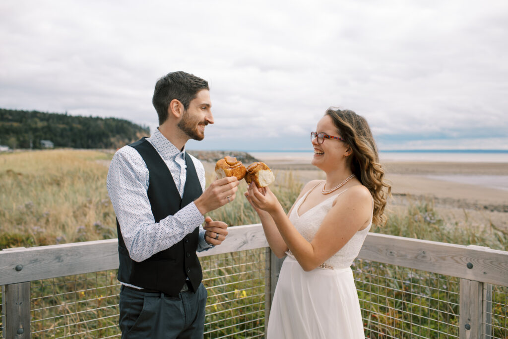 Bride and groom In Fundy New Brunswick sharing cinnamon rolls